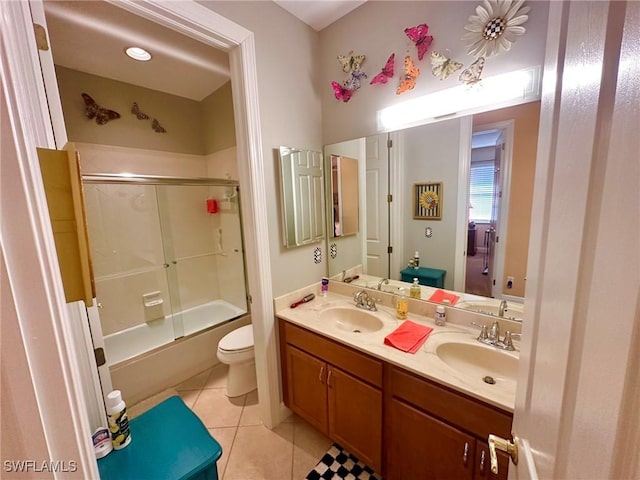 bathroom with tile patterned flooring, a sink, toilet, and double vanity