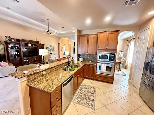 28880 Kiranicola Ct, Bonita Springs, FL 34135 - kitchen with arched walkways, a sink, appliances with stainless steel finishes, open floor plan, and light tile patterned floors
