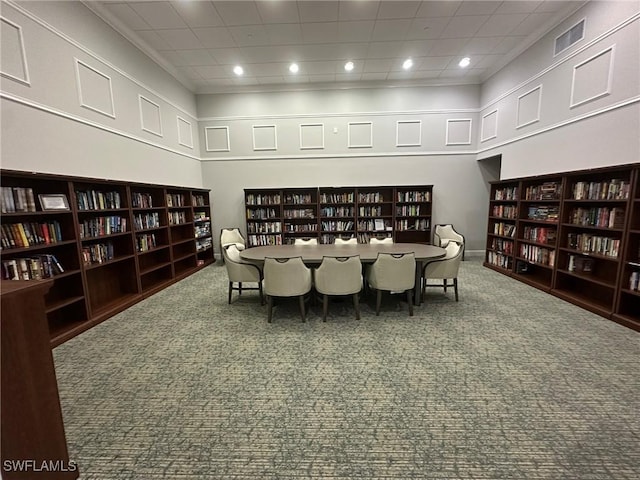 dining area with carpet, visible vents, and a high ceiling