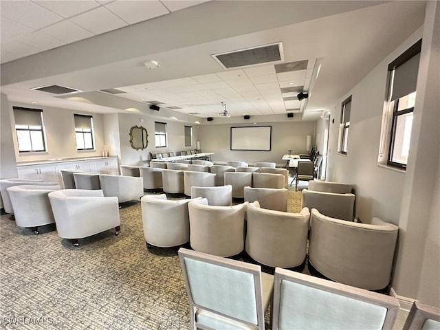 cinema with a paneled ceiling, visible vents, and carpet flooring