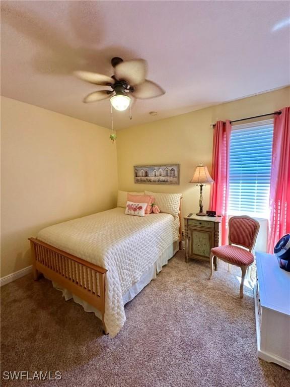 carpeted bedroom with a ceiling fan and baseboards