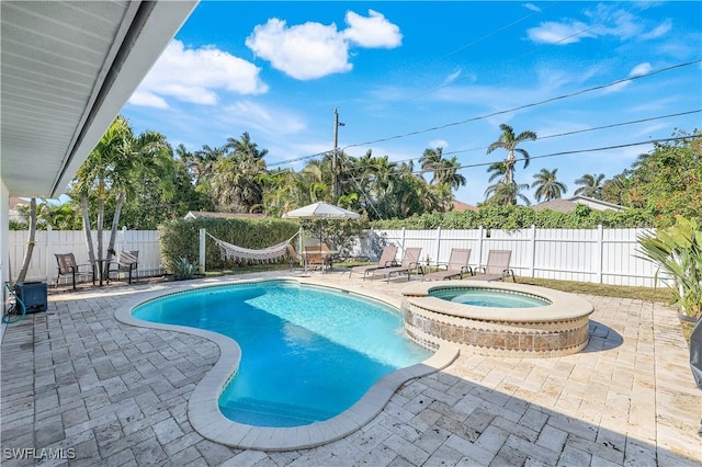 view of swimming pool featuring a patio and an in ground hot tub