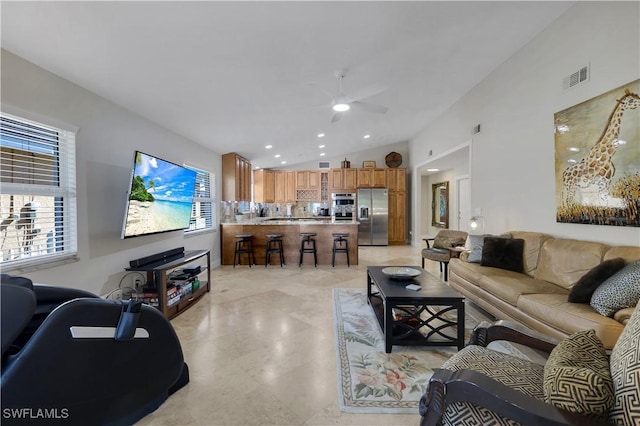 living room featuring ceiling fan and vaulted ceiling