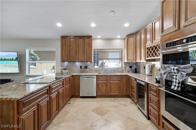 kitchen featuring appliances with stainless steel finishes, sink, beverage cooler, and kitchen peninsula