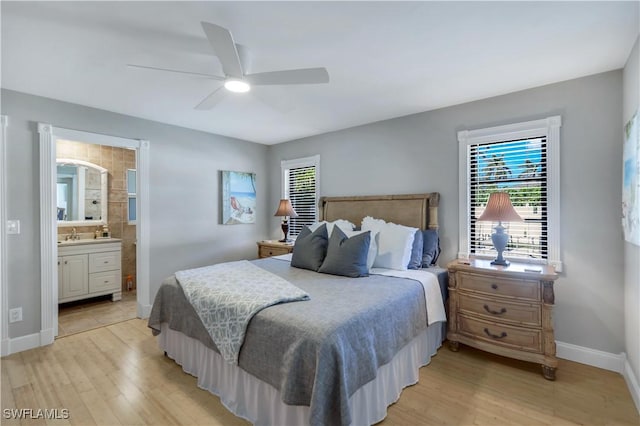 bedroom featuring ceiling fan, ensuite bathroom, and light wood-type flooring