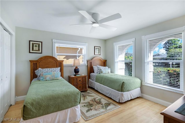 bedroom featuring light wood-type flooring, ceiling fan, and a closet