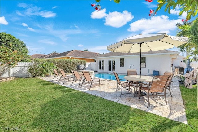 rear view of house with a fenced in pool, a patio area, and a lawn