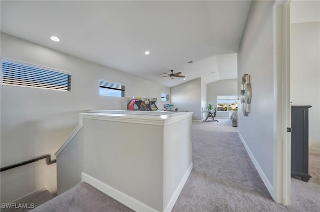 corridor featuring lofted ceiling, recessed lighting, light colored carpet, an upstairs landing, and baseboards