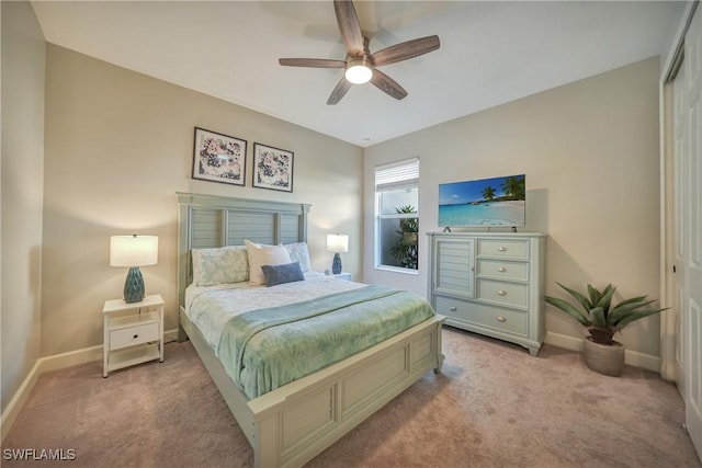 bedroom featuring a closet, light colored carpet, ceiling fan, and baseboards