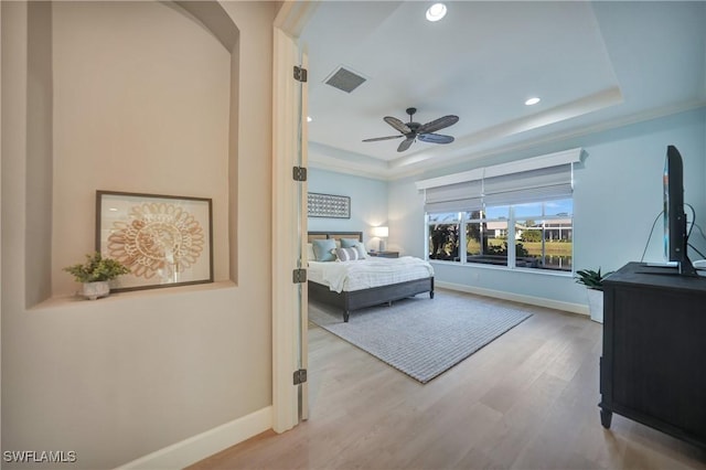 bedroom with light wood-style flooring, recessed lighting, visible vents, baseboards, and a tray ceiling