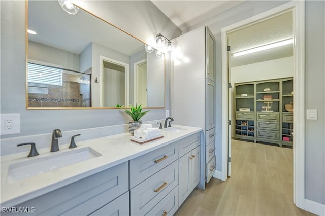 bathroom featuring walk in shower, wood-type flooring, and vanity