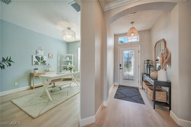 entryway with light hardwood / wood-style flooring and a chandelier