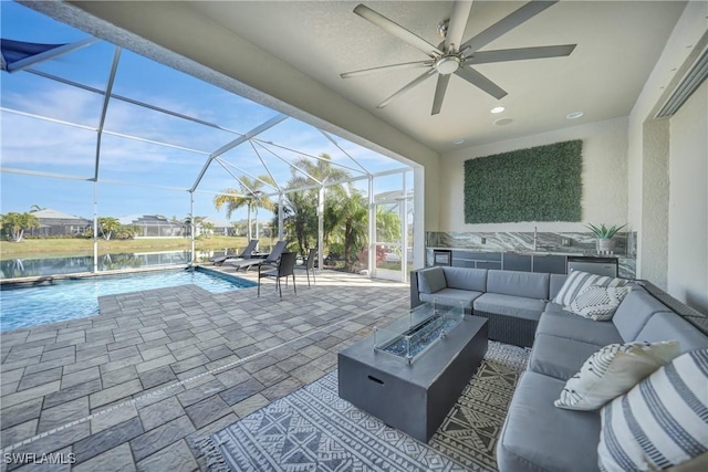 view of patio with a water view, an outdoor living space with a fire pit, and glass enclosure