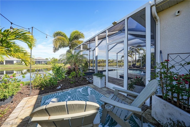 view of patio with a water view and glass enclosure