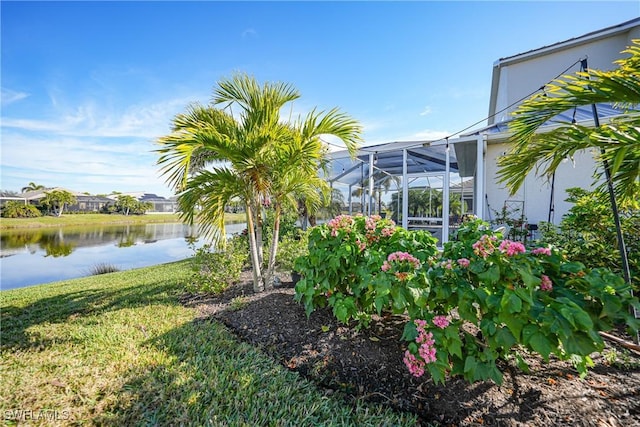 view of yard with a water view and glass enclosure