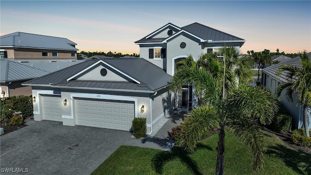 view of front of property with a garage, a standing seam roof, and decorative driveway