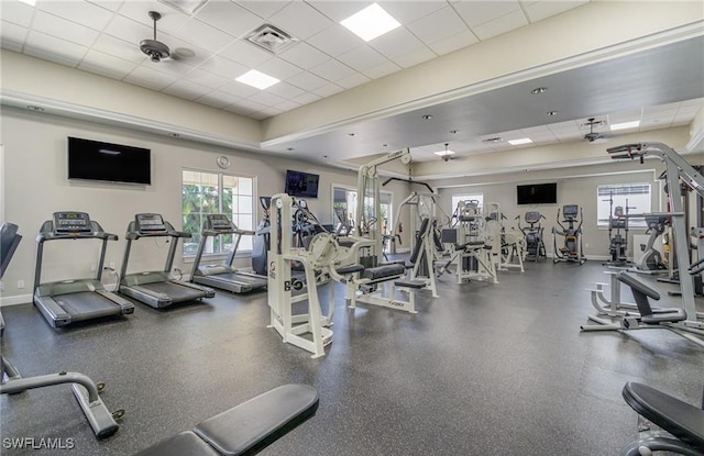 gym with visible vents, a drop ceiling, and baseboards