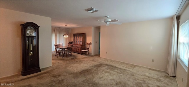 carpeted empty room with ceiling fan with notable chandelier and a wealth of natural light