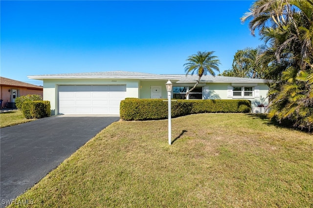 single story home with a garage and a front lawn