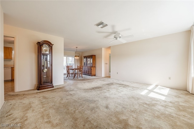 unfurnished living room featuring light colored carpet and ceiling fan