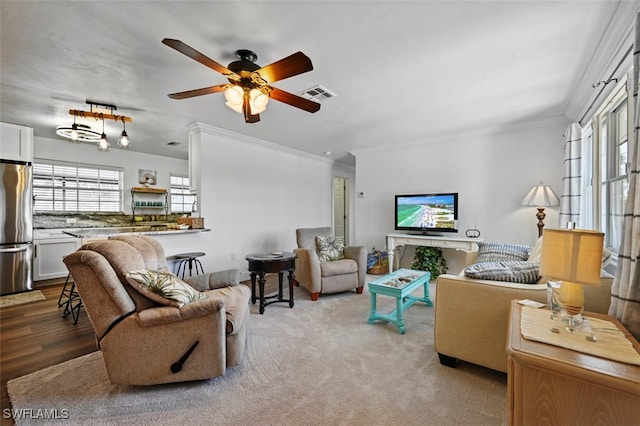 living room featuring crown molding, plenty of natural light, and ceiling fan