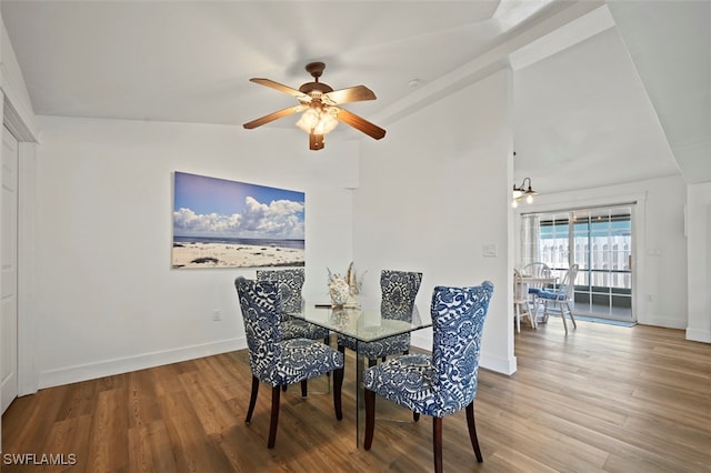 dining space with ceiling fan, lofted ceiling, and hardwood / wood-style floors