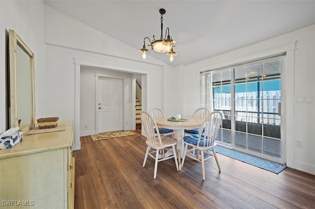 dining space with lofted ceiling, a notable chandelier, and dark wood-type flooring