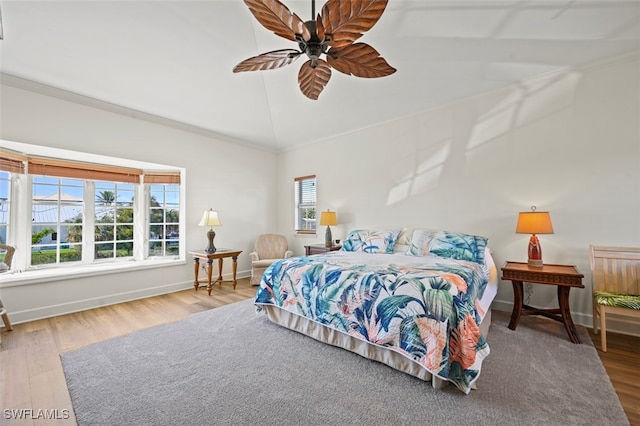 bedroom with vaulted ceiling, ceiling fan, ornamental molding, and hardwood / wood-style floors