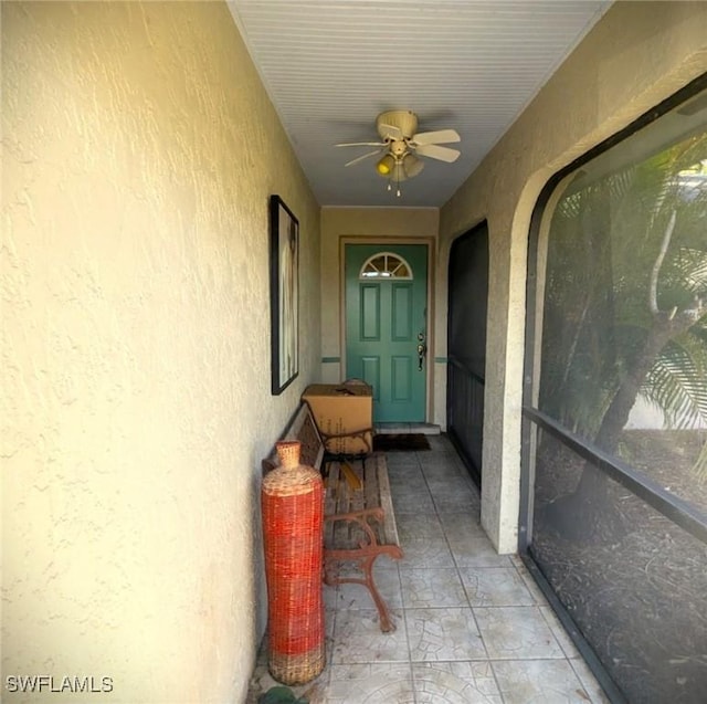 view of exterior entry featuring ceiling fan