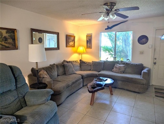 living room with ceiling fan, light tile patterned floors, and a textured ceiling