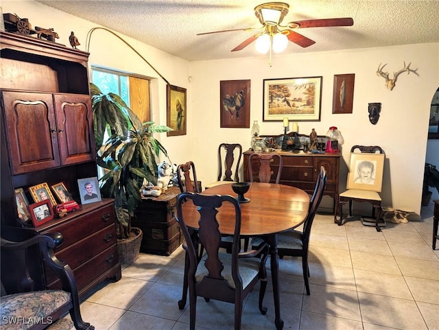 dining room featuring light tile patterned flooring, ceiling fan, and a textured ceiling