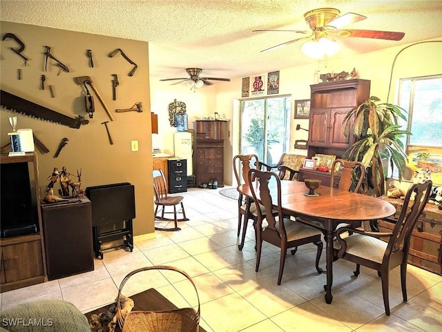 tiled dining space featuring ceiling fan and a textured ceiling