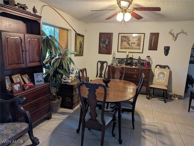 tiled dining space featuring ceiling fan and a textured ceiling