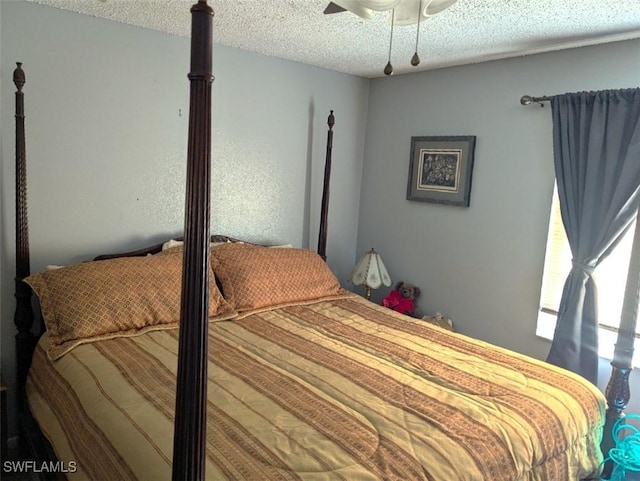 bedroom with ceiling fan and a textured ceiling