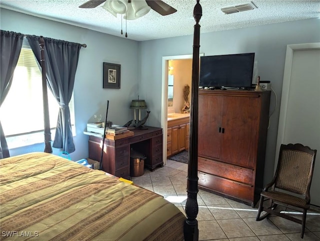 tiled bedroom with ceiling fan, ensuite bath, and a textured ceiling