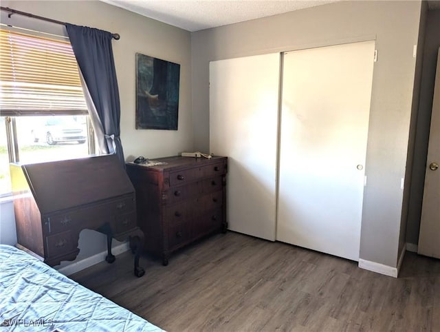 bedroom featuring hardwood / wood-style floors, a closet, and a textured ceiling