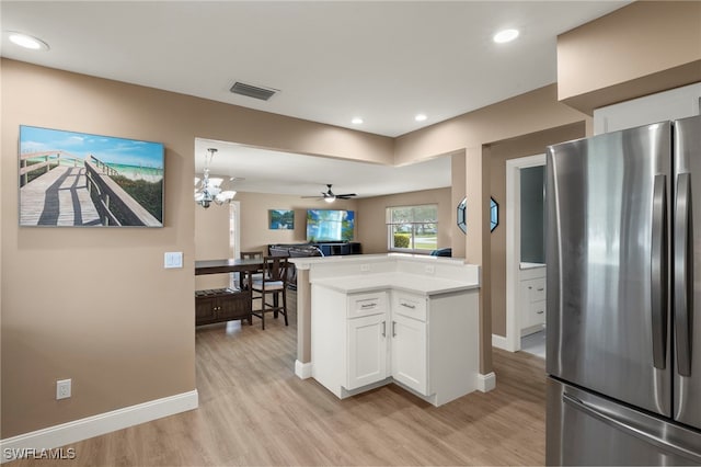 kitchen featuring stainless steel fridge, light hardwood / wood-style flooring, white cabinetry, ceiling fan with notable chandelier, and kitchen peninsula