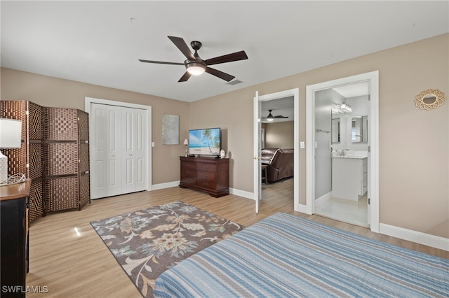 bedroom with sink, ensuite bath, a closet, ceiling fan, and light hardwood / wood-style floors