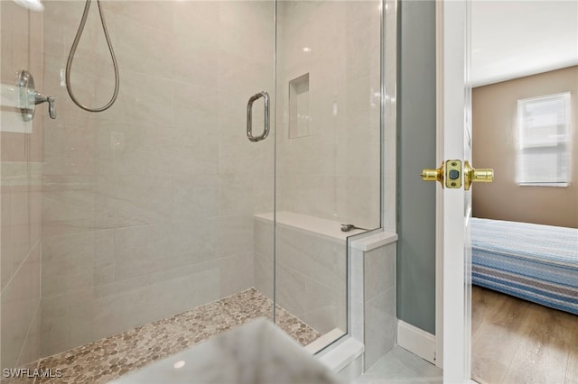 bathroom with hardwood / wood-style floors and an enclosed shower