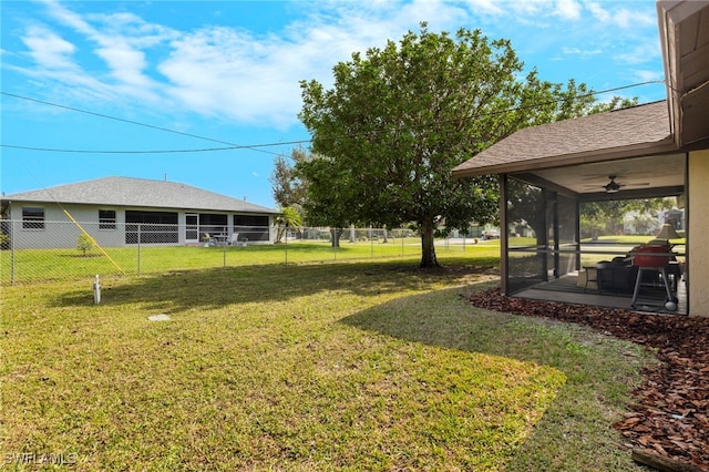 view of yard featuring a sunroom and ceiling fan