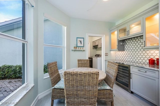 interior space featuring gray cabinets, tasteful backsplash, white electric stove, wine cooler, and light stone counters