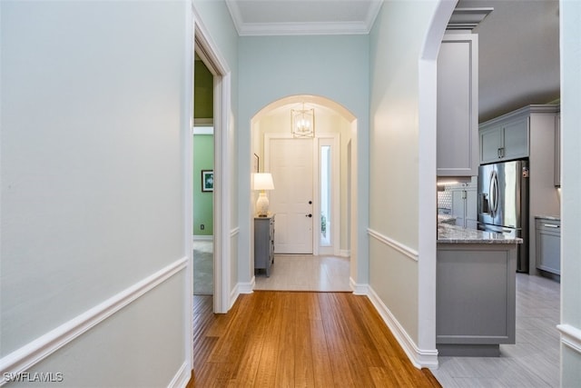 hall featuring crown molding and light hardwood / wood-style flooring