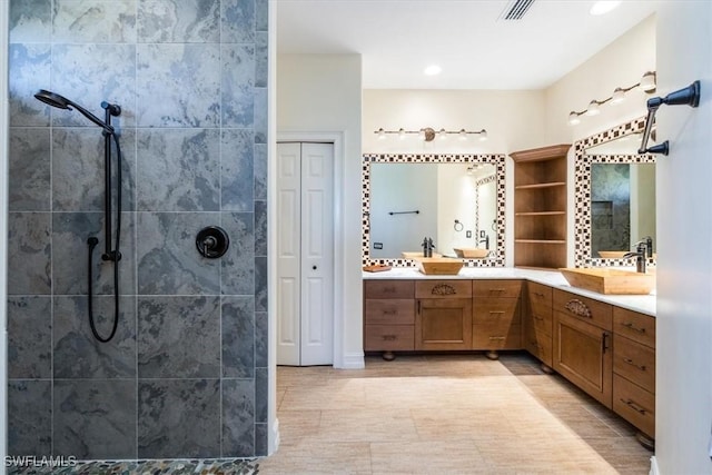 bathroom with tiled shower and vanity