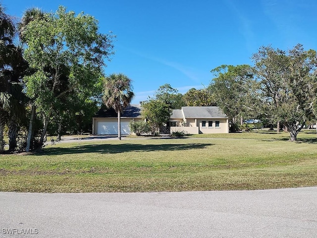 view of front of home with a garage and a front lawn