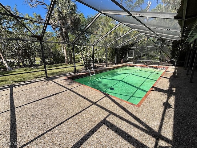 view of swimming pool with glass enclosure and a patio area