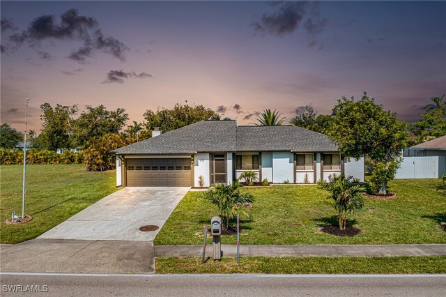 view of front of house with a yard and a garage