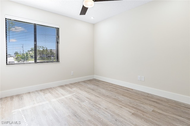 spare room with ceiling fan, light hardwood / wood-style floors, and a textured ceiling