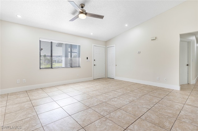 unfurnished room featuring ceiling fan, light tile patterned floors, a textured ceiling, and lofted ceiling