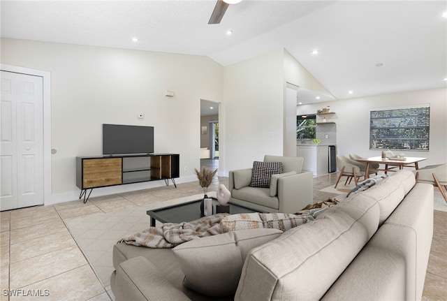 living room with ceiling fan, light tile patterned floors, and vaulted ceiling