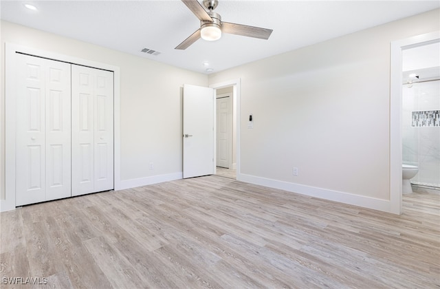 unfurnished bedroom featuring a closet, connected bathroom, ceiling fan, and light hardwood / wood-style flooring